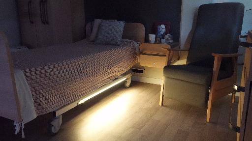 Bandeau LED Noctulys installé sous un lit médicalisé