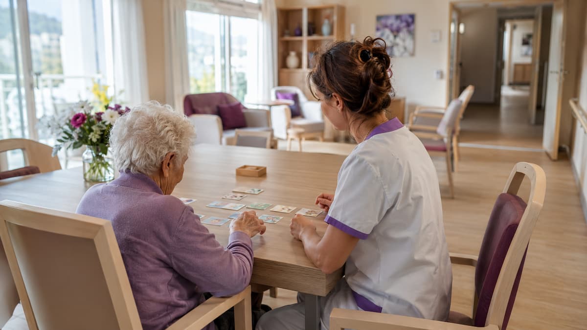 Soignante accompagnant un résident pendant une activité adaptée dans un PASA en EHPAD