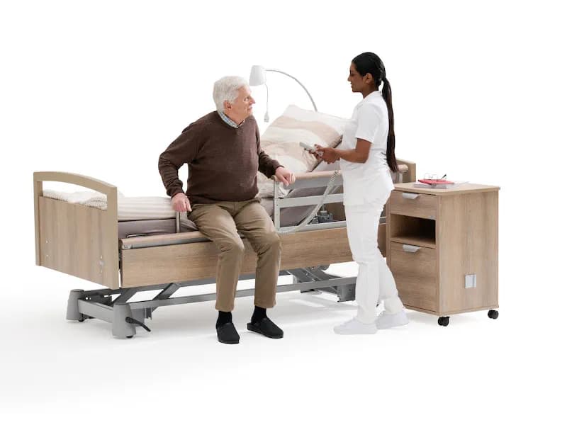 Lit médicalisé en position basse avec protections latérales dans une chambre d’EHPAD
