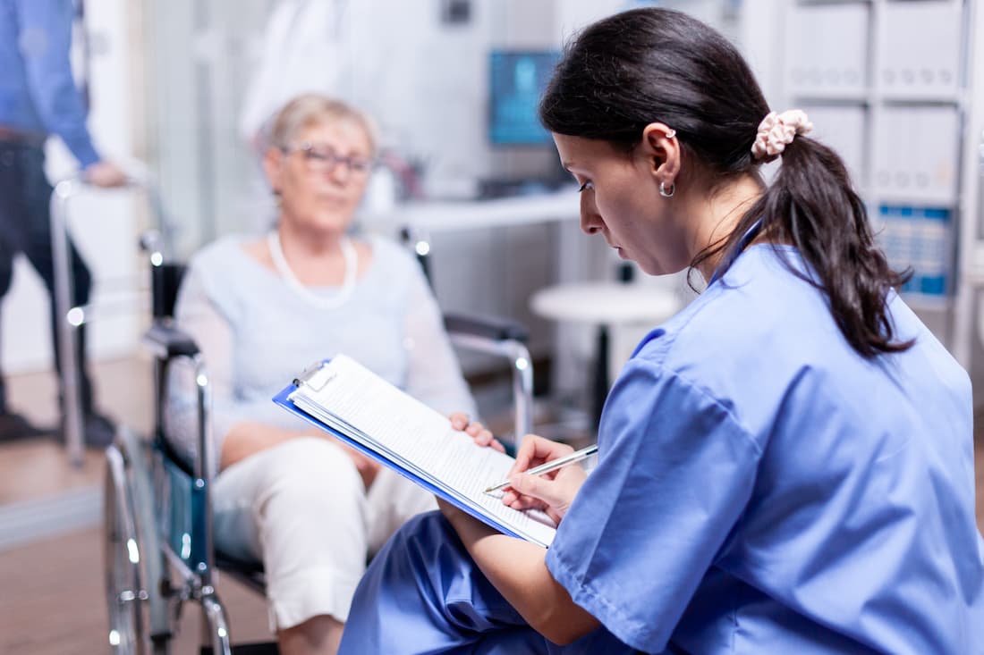 Professionnelle de santé analysant des données de soins avec un interlocuteur en EHPAD