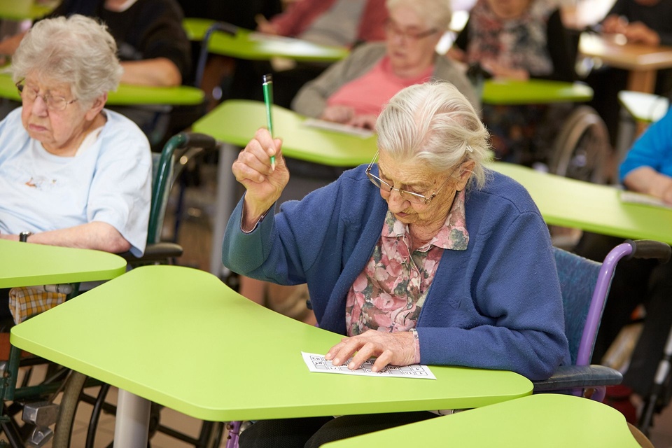 Une résidente participe à une activité avec une table adaptée